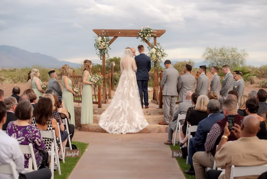 Vows at the ceremony arch with mountain views