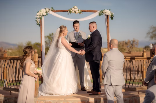 Exchanging vows at the flower-topped arch