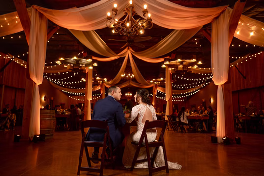 The draped pavilion glowing with chandeliers and string lights