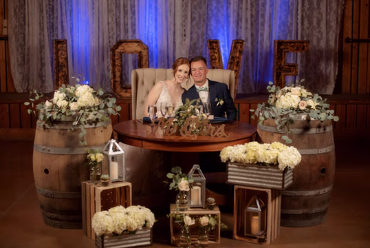 A styled sweetheart table with florals and marquee letters
